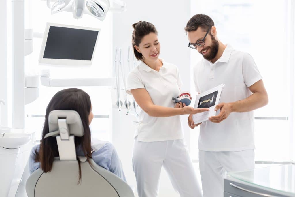 Médicos enseñando a un paciente una radiografía dental